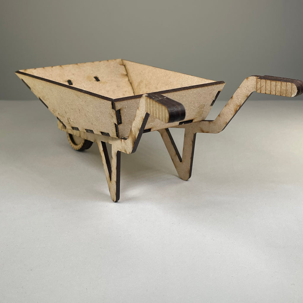 Curious Rabbit wheelbarrow planter garden kit with assembled flatpack model, featuring a mini wheelbarrow design with planting space.
