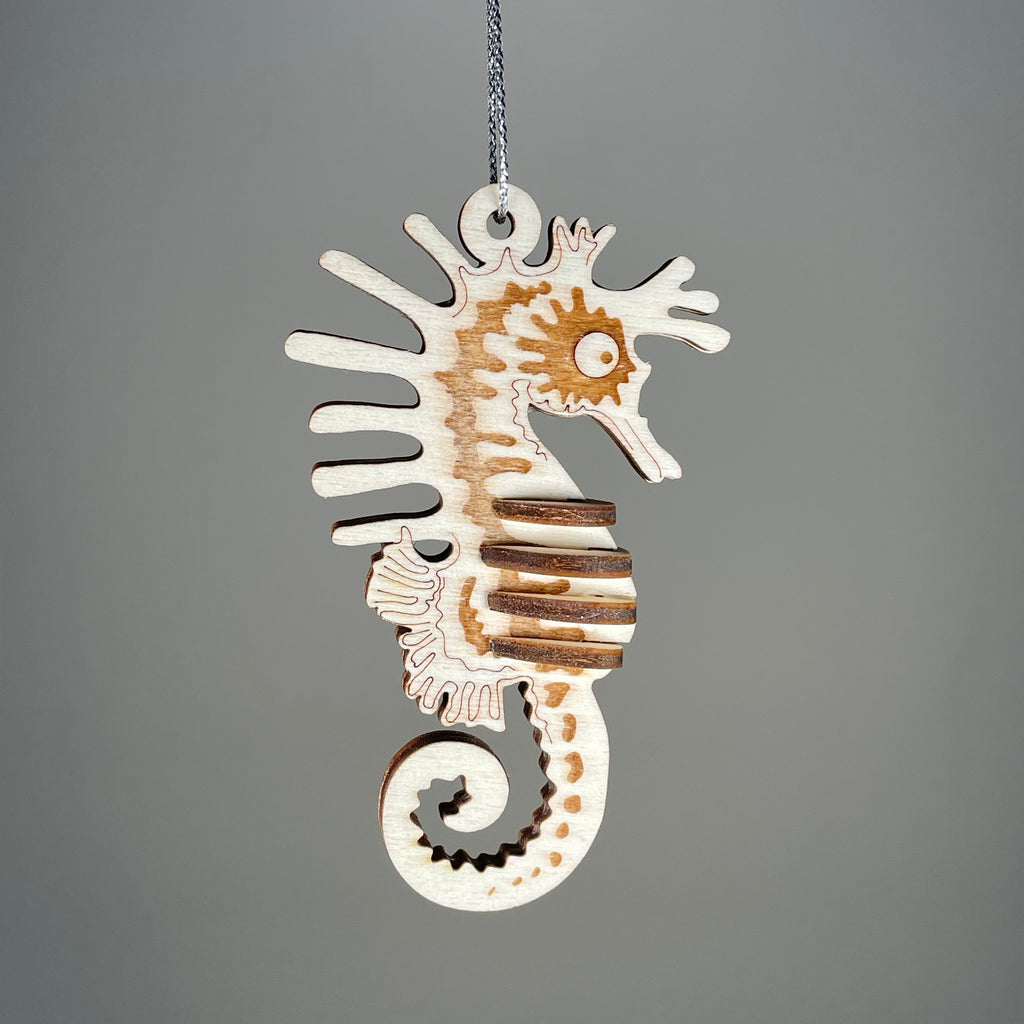 Curious Rabbit seahorse bauble flatpack model kit with beach-themed design, showing assembled or unassembled colorful plastic parts.