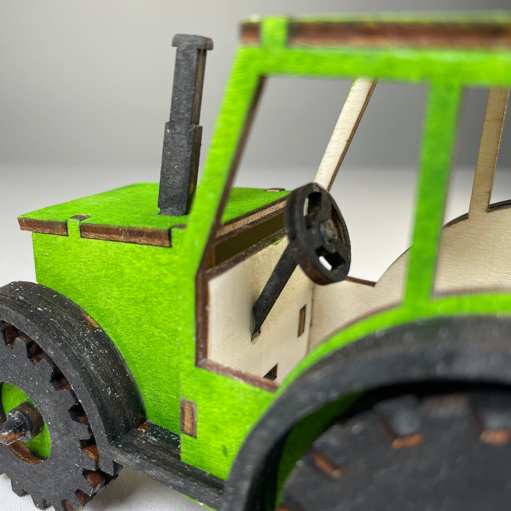Curious Rabbit garden tractor puzzle flatpack model kit, assembled with colorful plastic pieces and detailed tractor design.