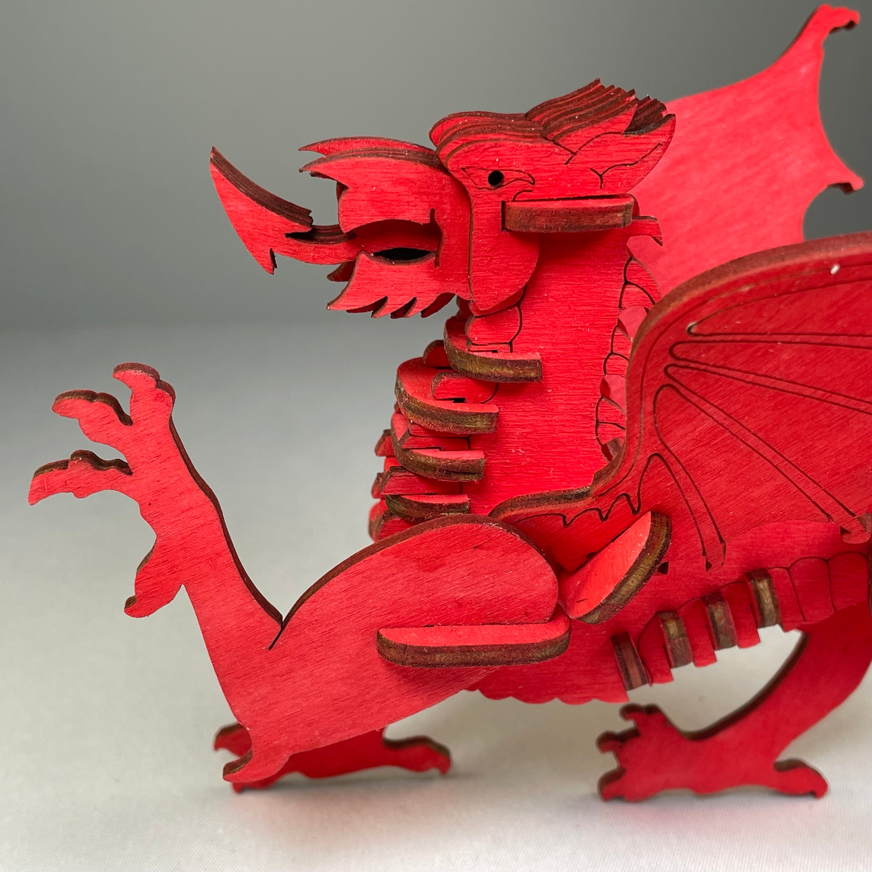 Welsh Dragon Puzzle flatpack model kit by Curious Rabbit, showing assembled colorful dragon figure on a white background.