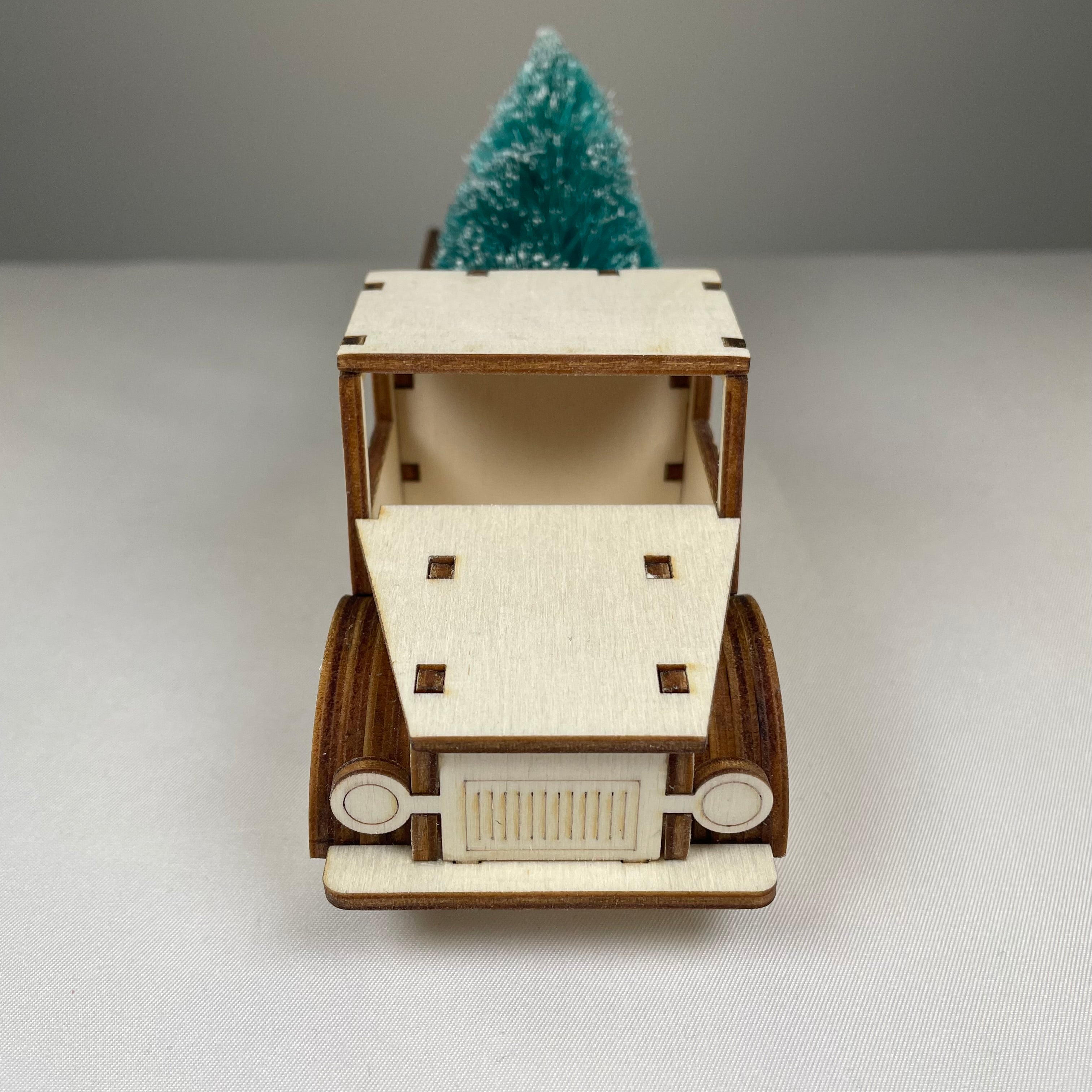 Curious Rabbit flatpack Christmas truck model kit with a Christmas tree inside, assembled as a detailed paper craft.