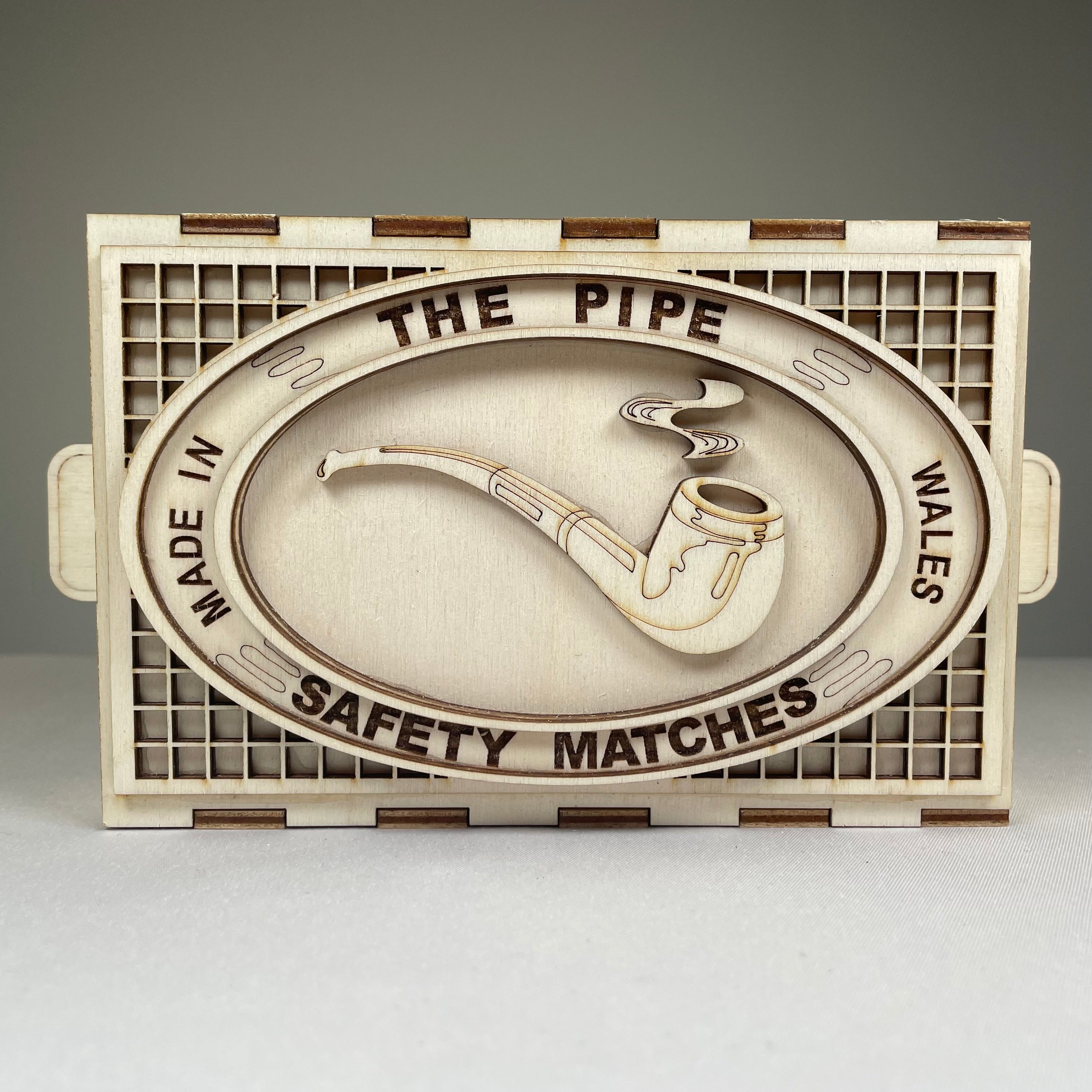 Vintage Curious Rabbit matchbox pipe flatpack model kit with assembled pipe and packaging on a white background.