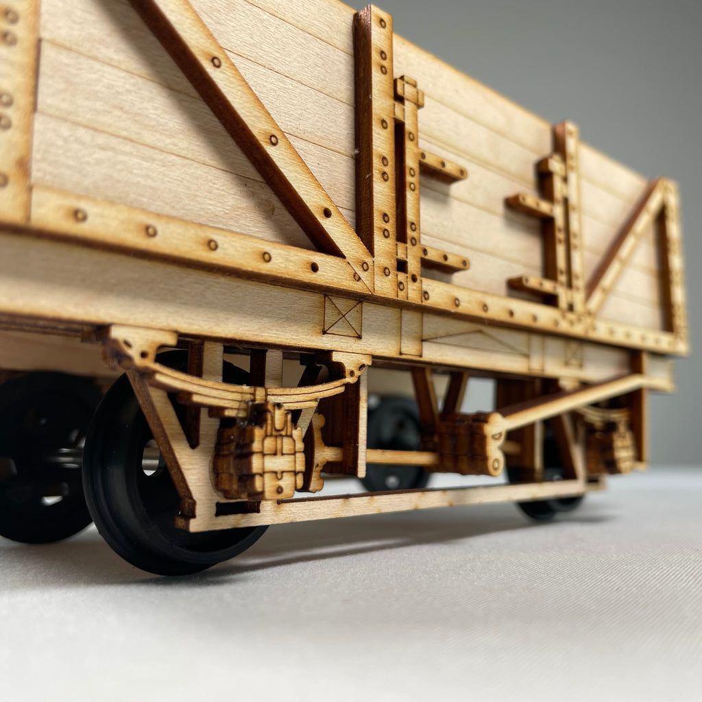 Curious Rabbit railway train wagon flatpack model kit, showing unassembled wooden train car parts on a white background.