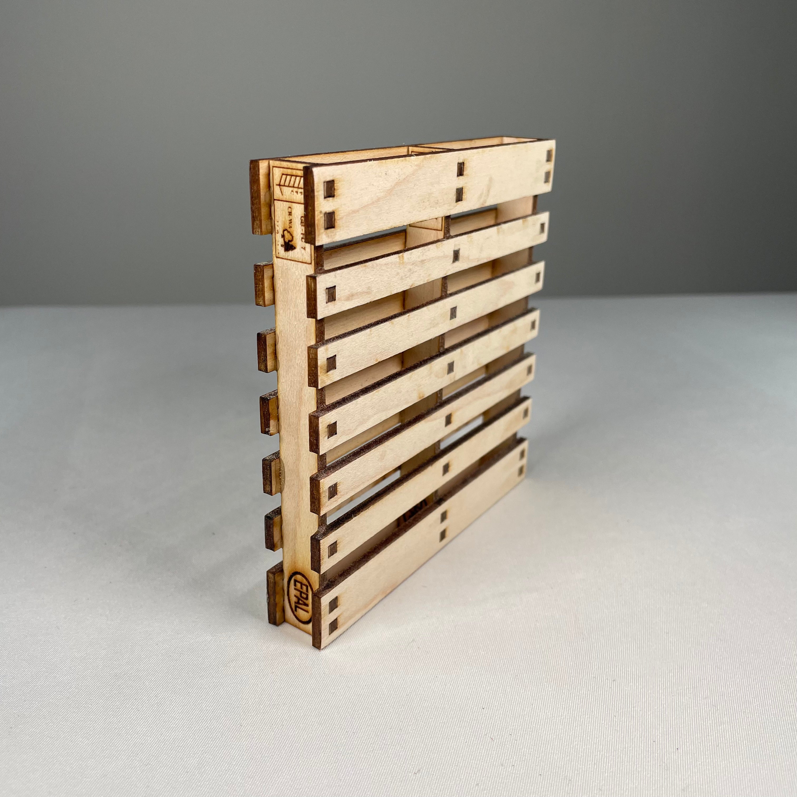 Curious Rabbit flatpack pallet coaster icon kit, showing unassembled wooden coaster pieces with engraved design, ready for assembly.