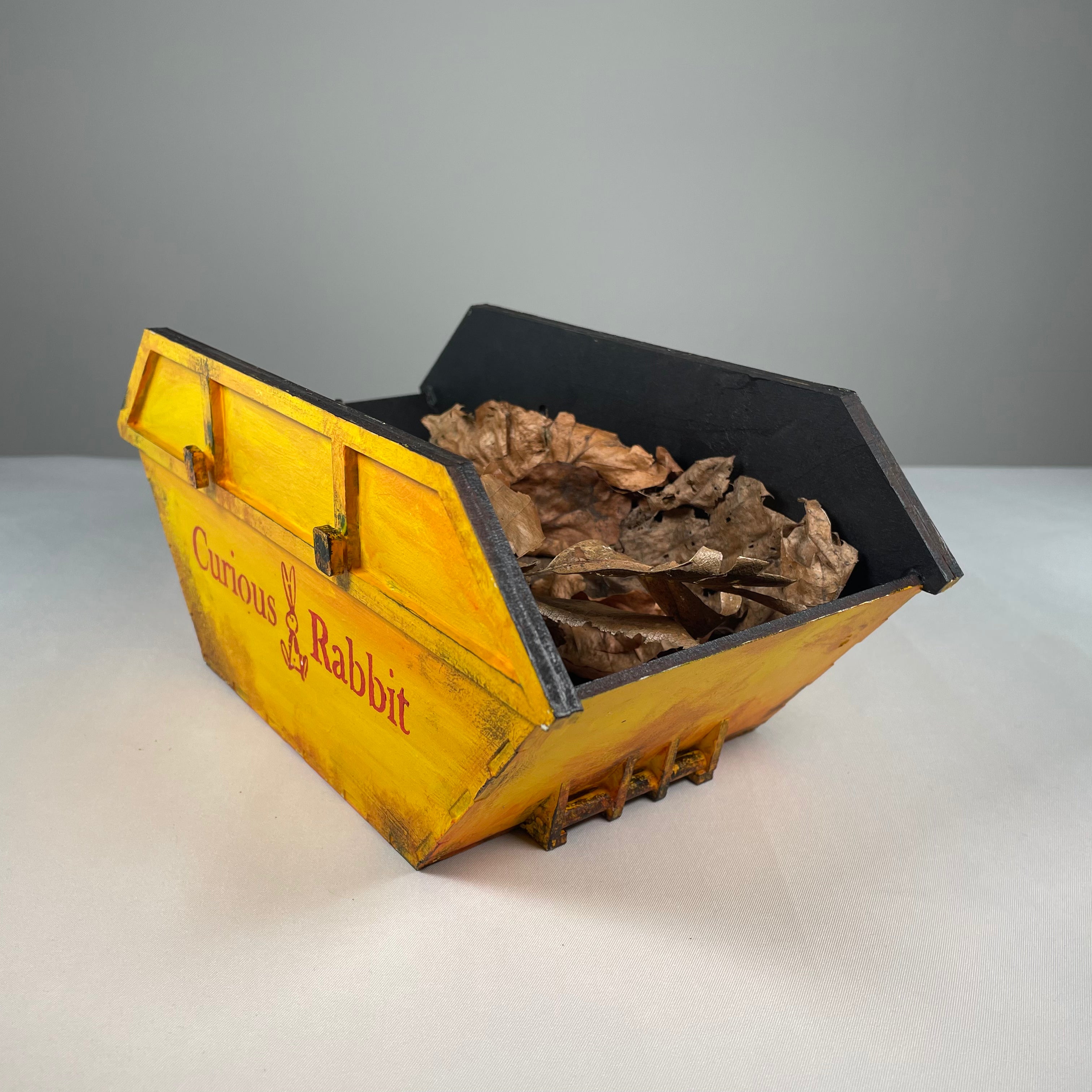 Flatpack Curious Rabbit Skip Waste Container icon kit showing assembled waste bin with lid and handle, designed for easy disposal.