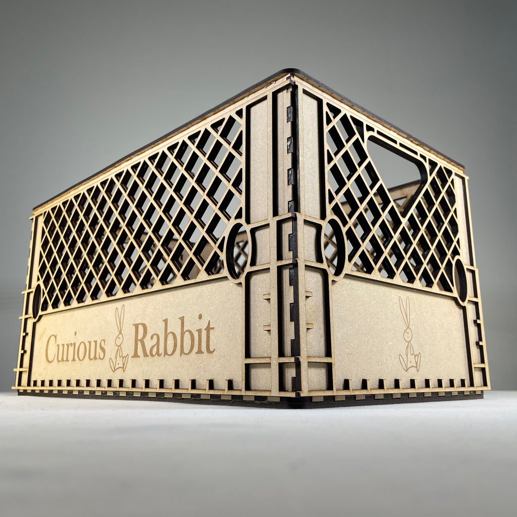 Vintage Curious Rabbit flatpack milk crate model kit, showing assembled wooden crate with slatted sides and sturdy handle.