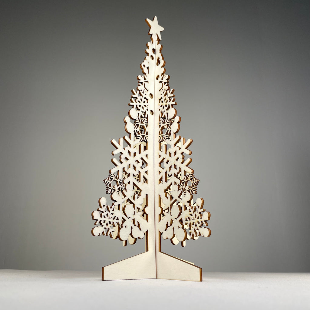 Curious Rabbit flatpack Christmas Tree #3 model kit with green branches and wooden base, ready for assembly.