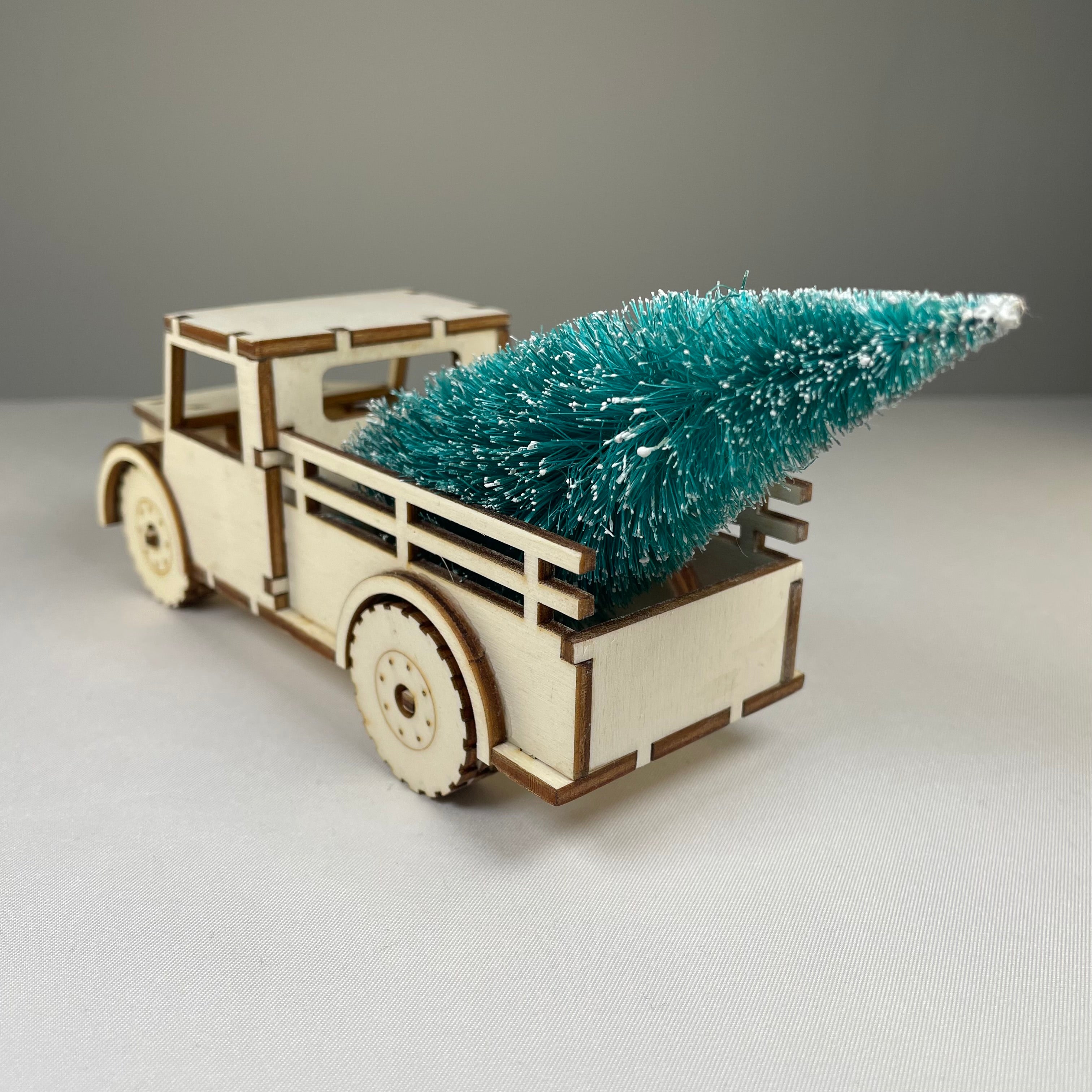 Curious Rabbit Christmas truck flatpack model kit with a decorated Christmas tree, ready to assemble, festive holiday decor.