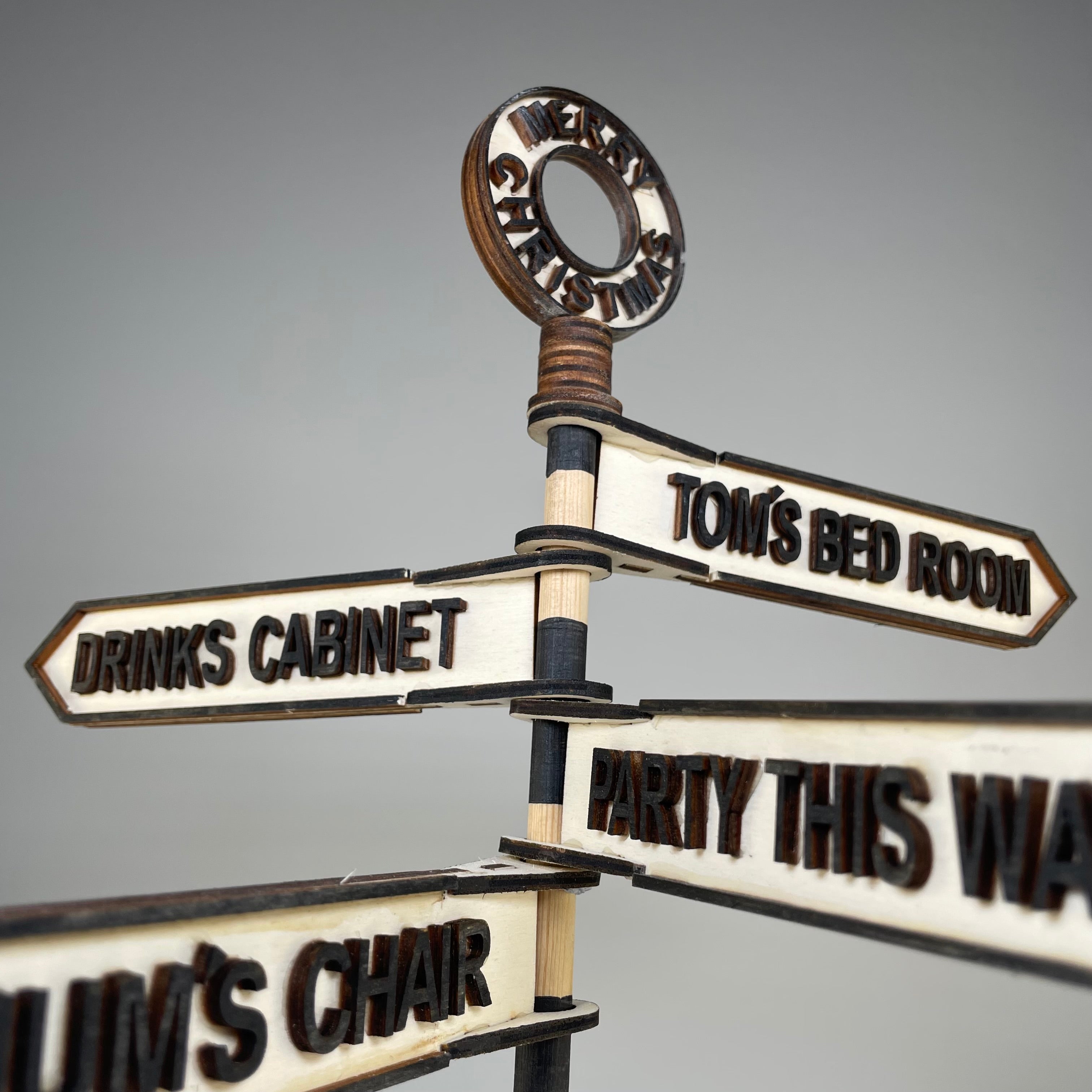 Handmade Curious Rabbit Christmas direction sign ornament with festive holiday design and colorful lettering on wood.