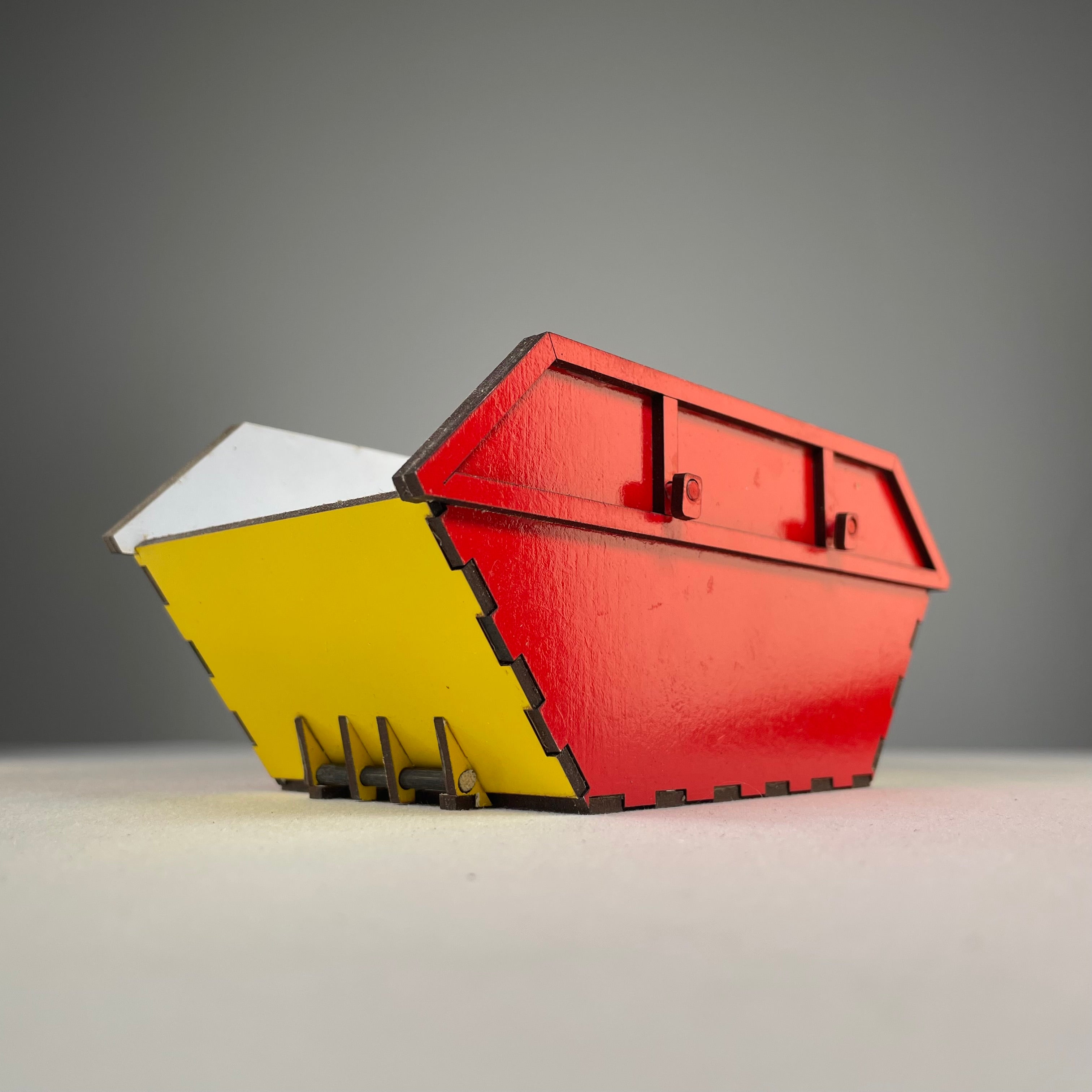 Curious Rabbit Skip Waste Container flatpack icon kit with assembled container illustration on white background