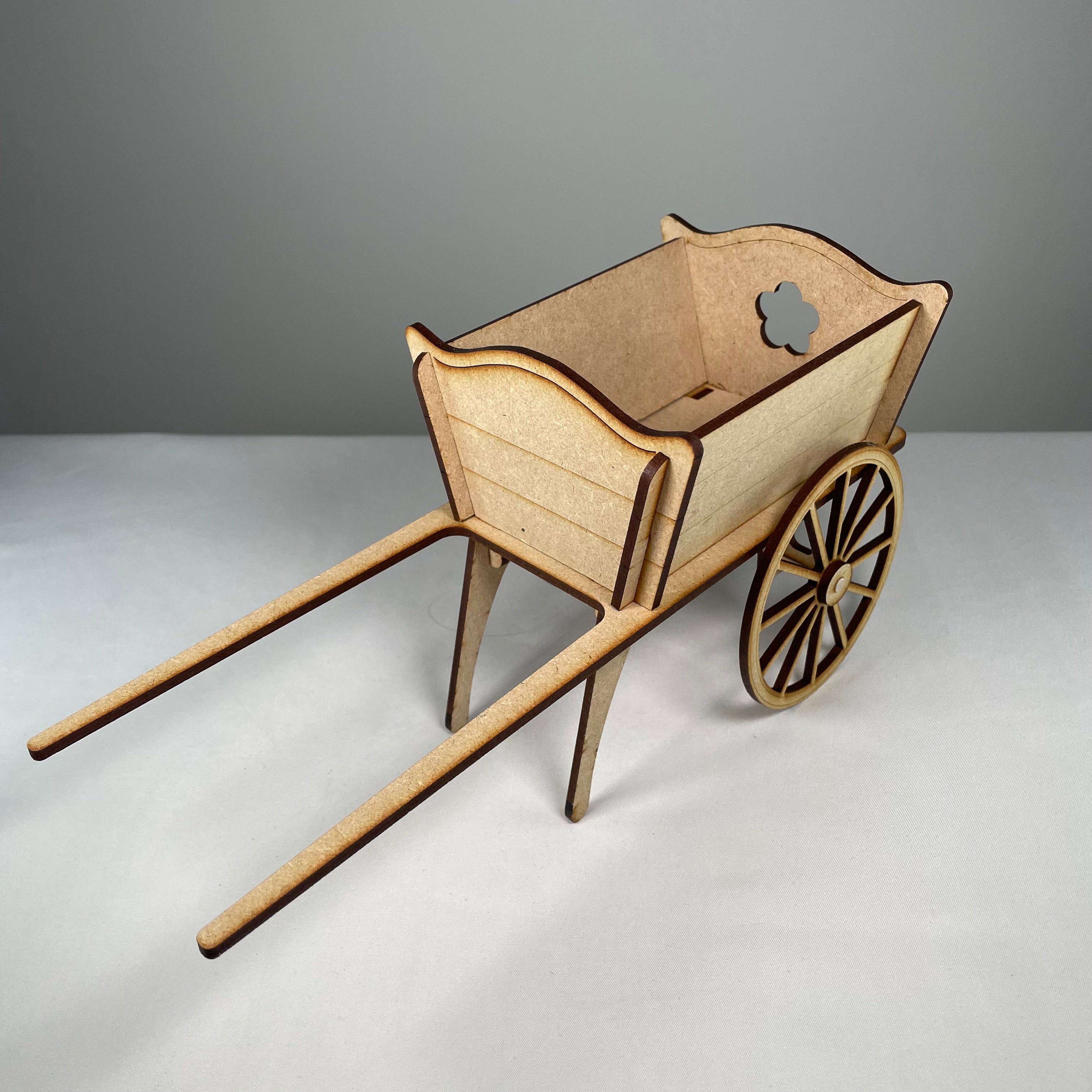 Curious Rabbit cart planter flatpack garden kit with wooden parts and wheels, assembled for decorative outdoor planting.