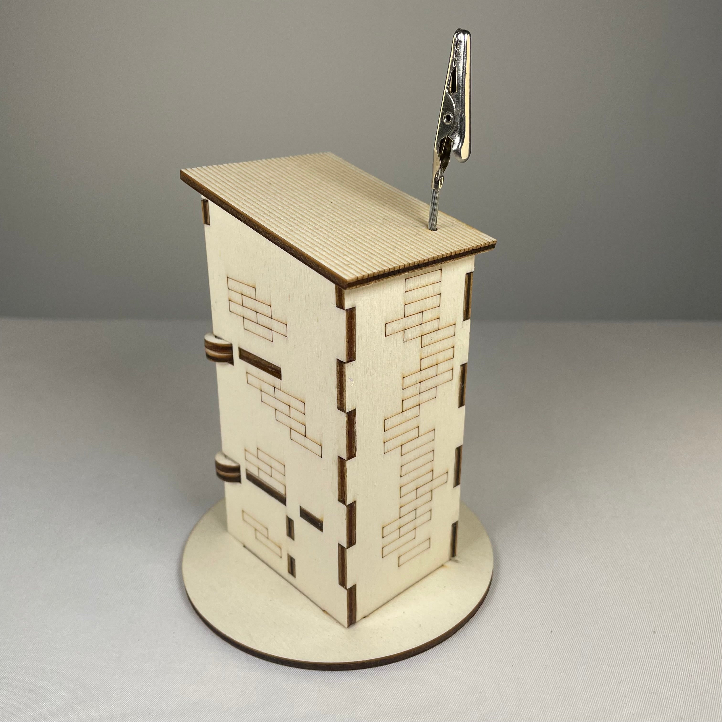 Curious Rabbit Outhouse Toilet flatpack memo holder with architectural design, showcasing detailed model and packaging.