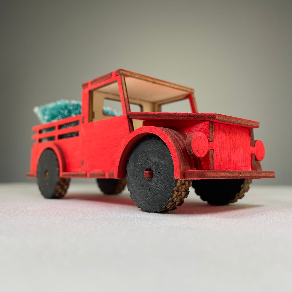 Curious Rabbit flatpack Christmas truck model kit with a Christmas tree, assembled with detailed festive design.