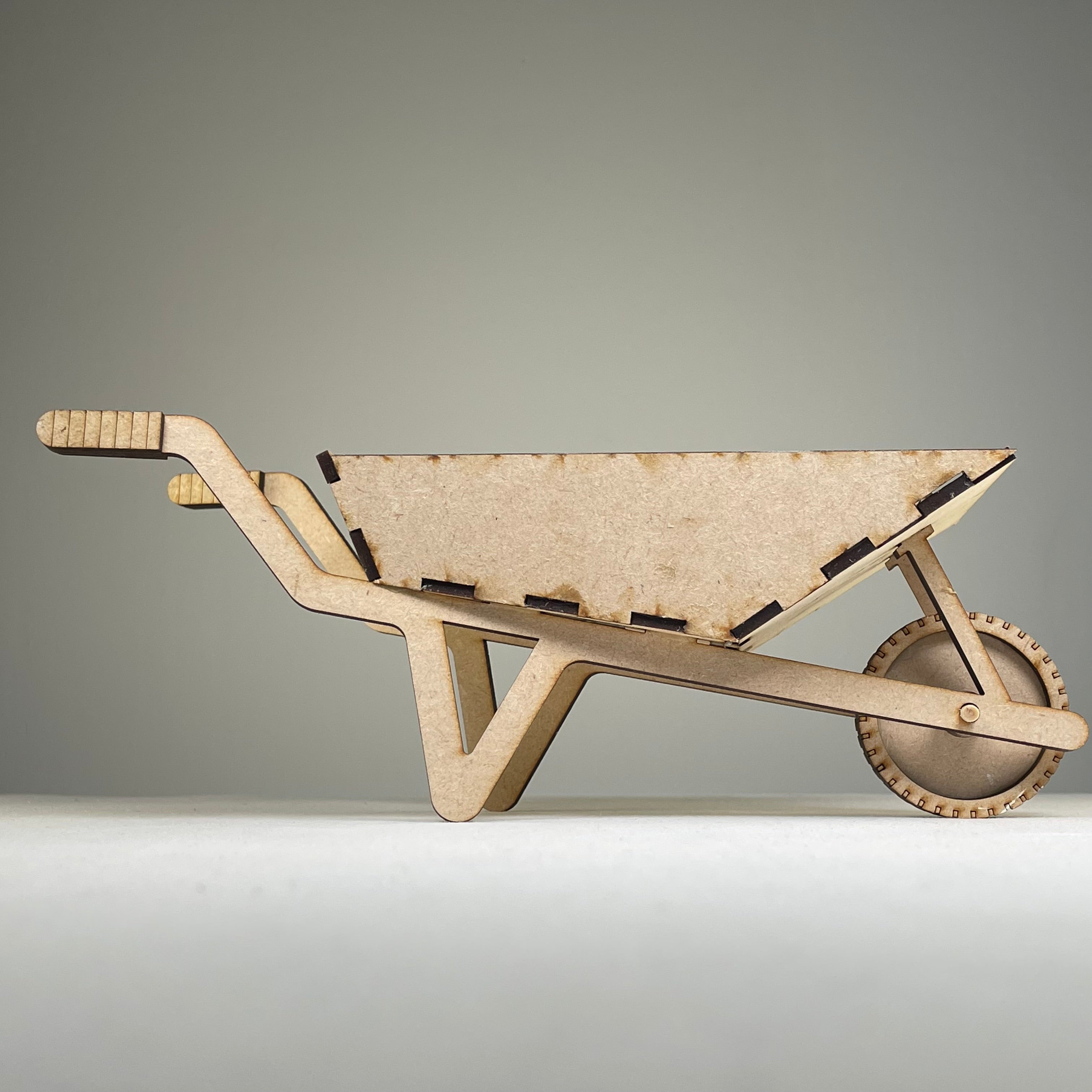 Curious Rabbit wheelbarrow planter garden kit with flatpack design, shown assembled with plants inside for outdoor gardening.