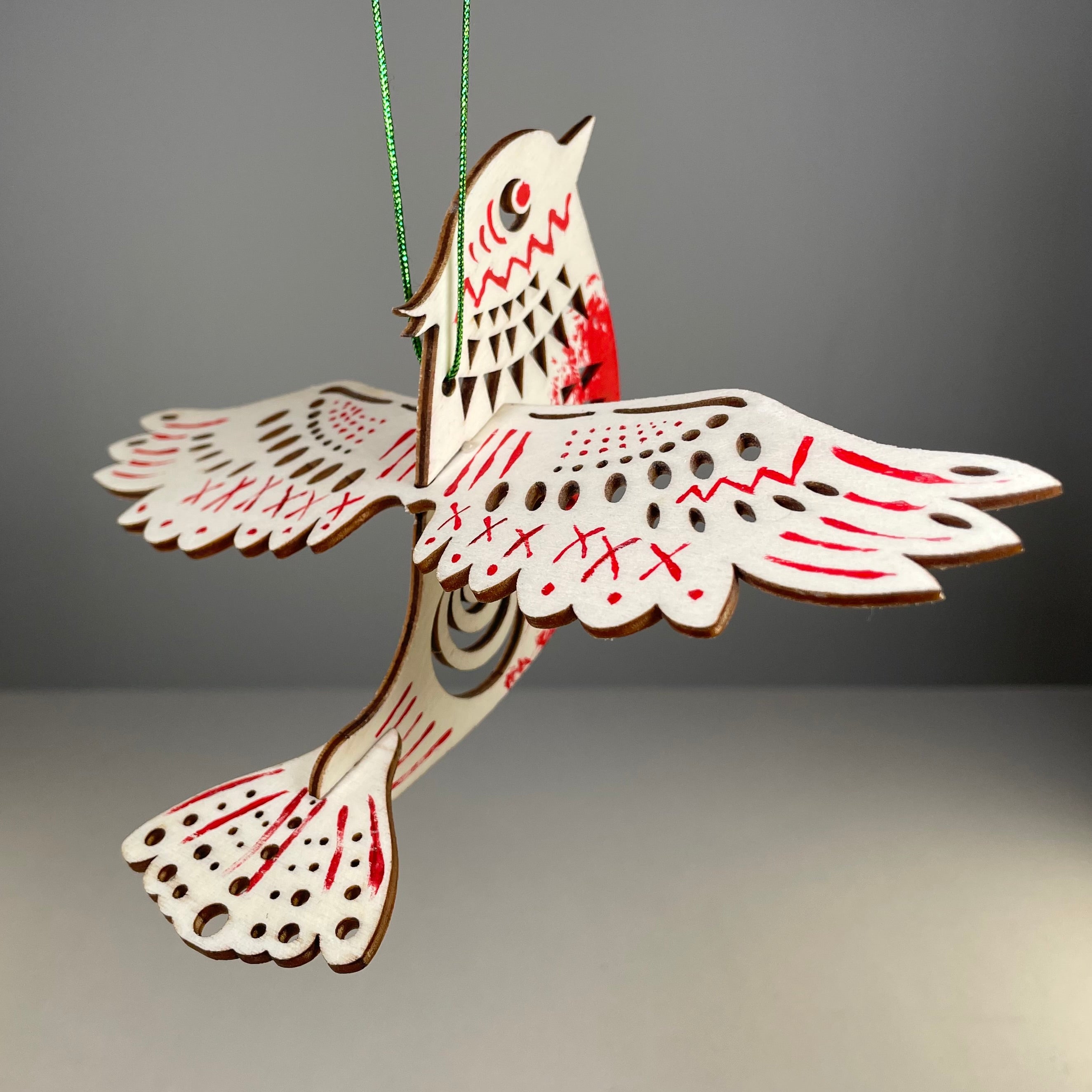 Handmade Christmas bird bauble ornament in vibrant colors, designed by Curious Rabbit for festive holiday decor.