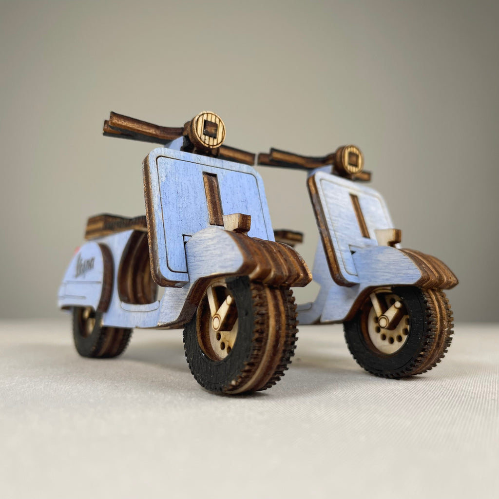 Vintage retro scooter flatpack model kit by Curious Rabbit assembled with colorful parts on a white background.