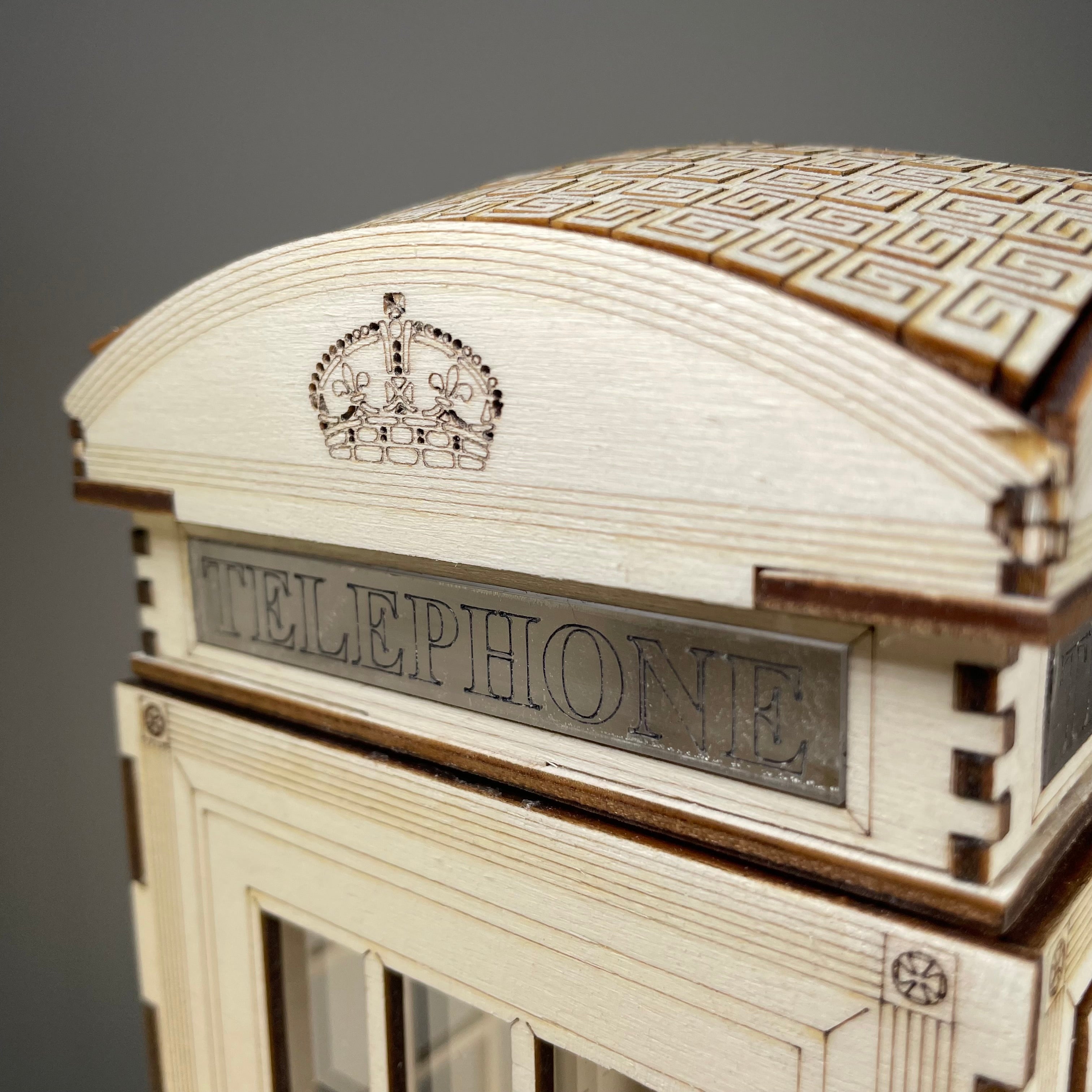 Curious Rabbit Telephone Box Lamp flatpack model kit icon, showing a miniature vintage red telephone booth with detailed design.