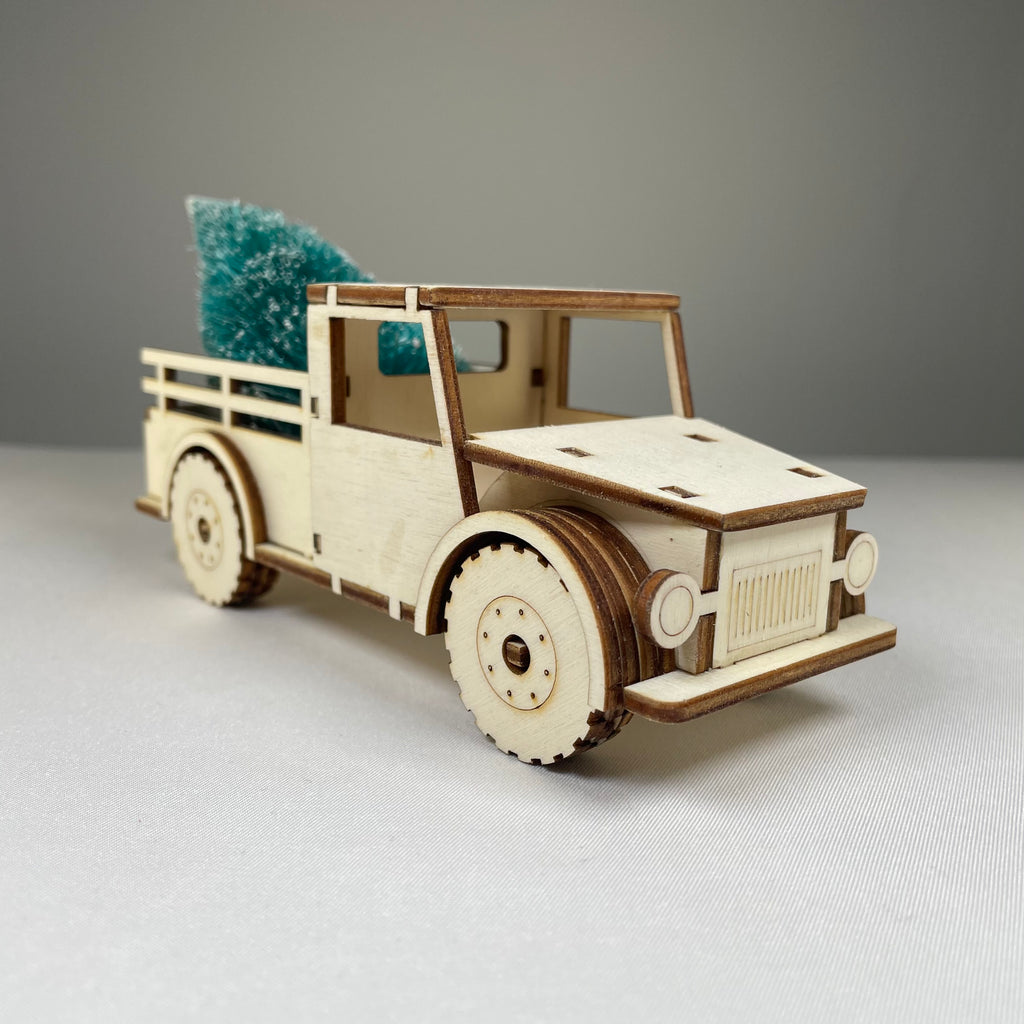 Curious Rabbit flatpack Christmas truck model kit with a Christmas tree, ready for assembly and holiday decor.