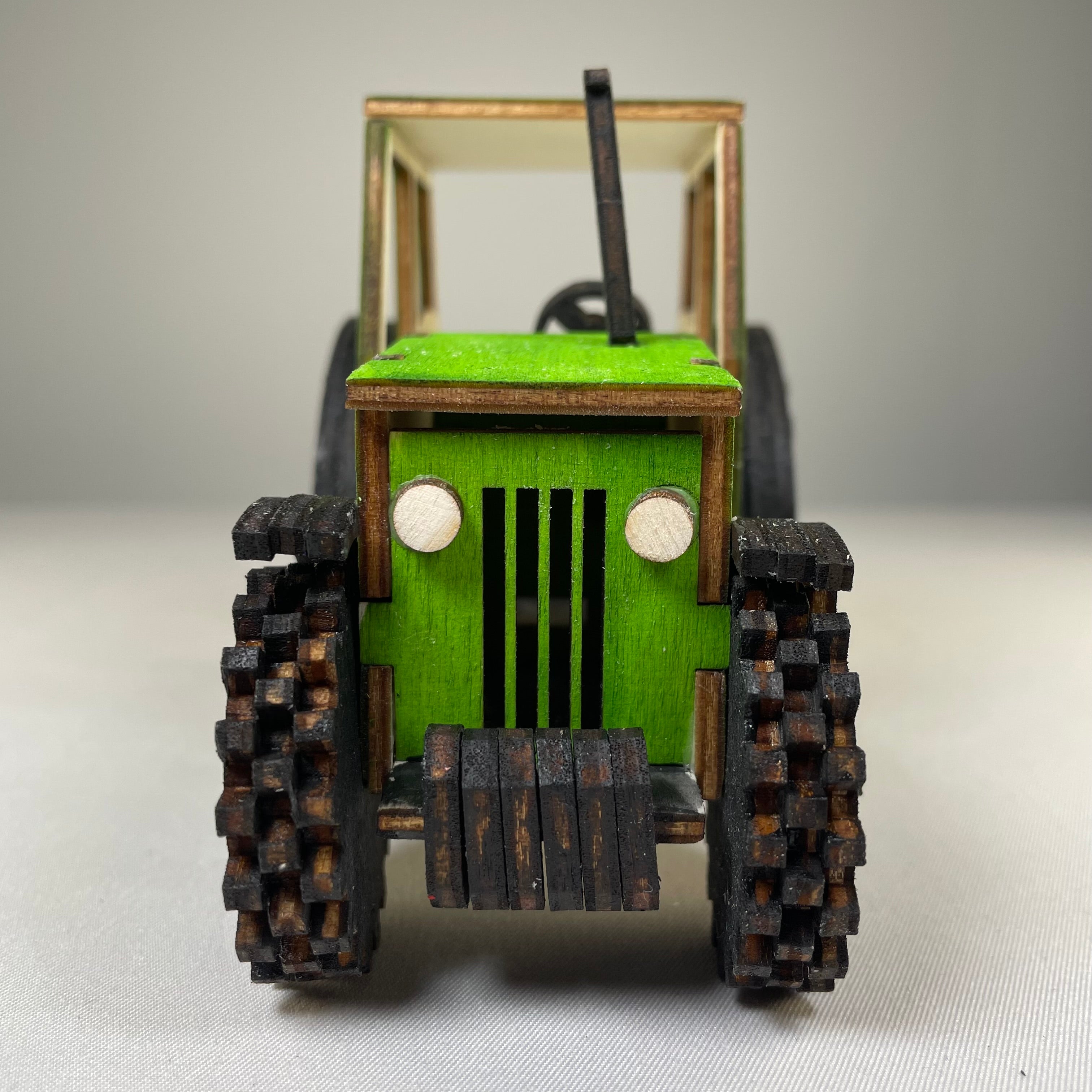 Garden tractor puzzle by Curious Rabbit, flatpack model kit featuring colorful, detailed tractor parts for assembly.