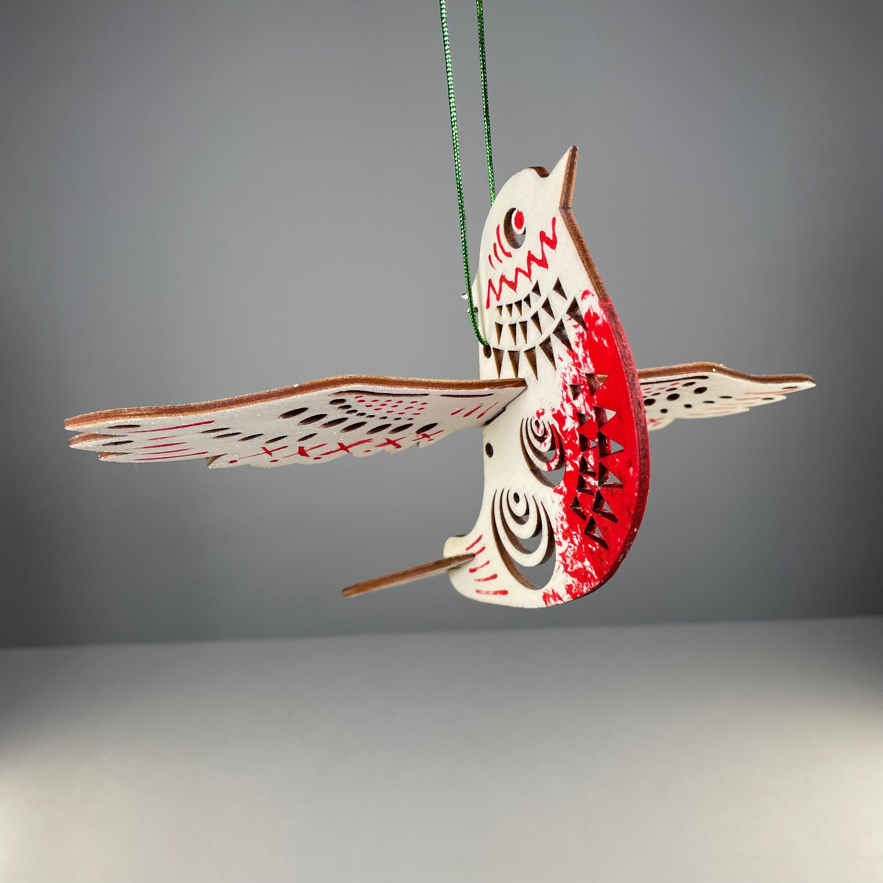 Handmade Christmas bird bauble ornament by Curious Rabbit featuring festive holiday design on a shiny Christmas tree decoration.