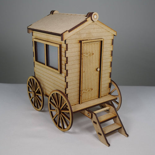 Curious Rabbit beach bathing hut flatpack model kit, assembled with wooden panels and beach accessories, outdoors on sand.