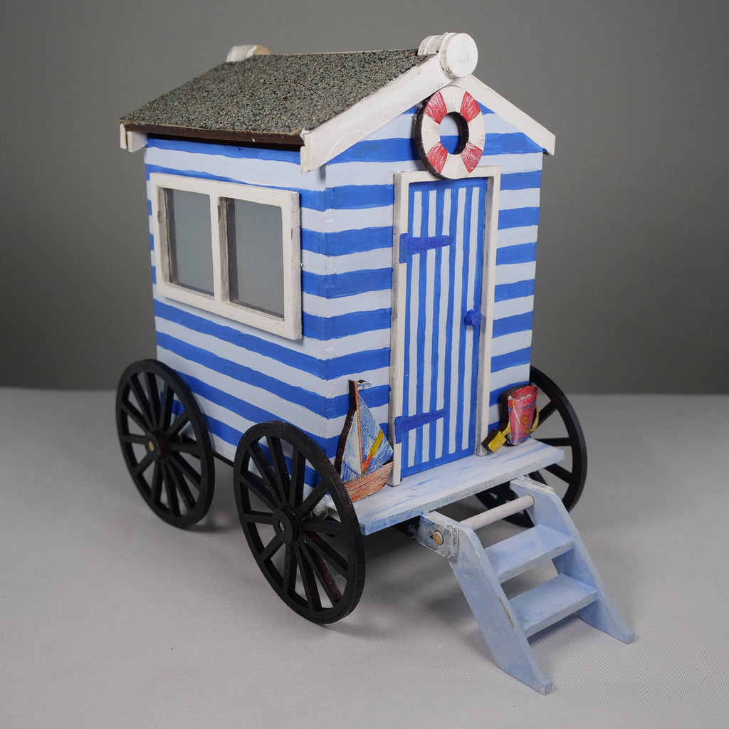 Curious Rabbit flatpack beach bathing hut model kit with detailed components and a seaside setting for creative building.