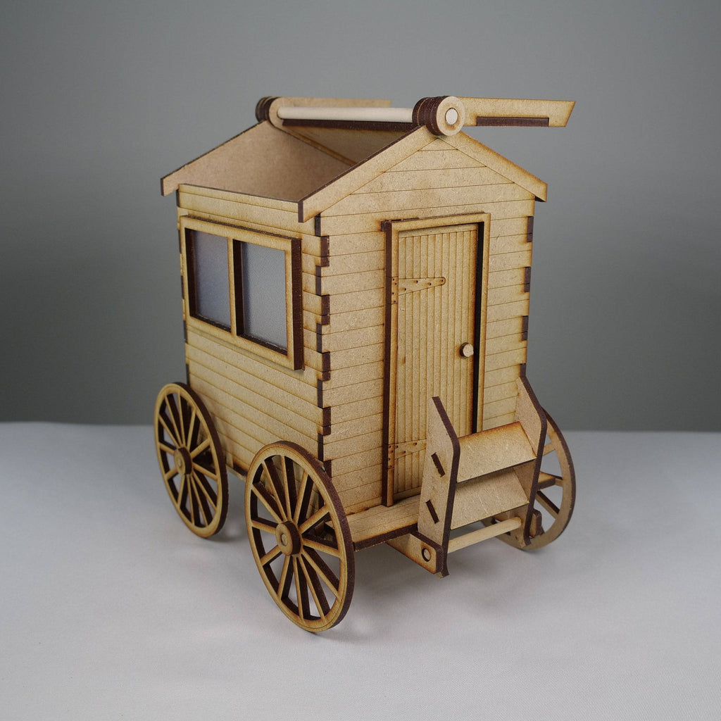 Curious Rabbit flatpack beach bathing hut model kit, assembled and displayed outdoors with a sandy beach background.