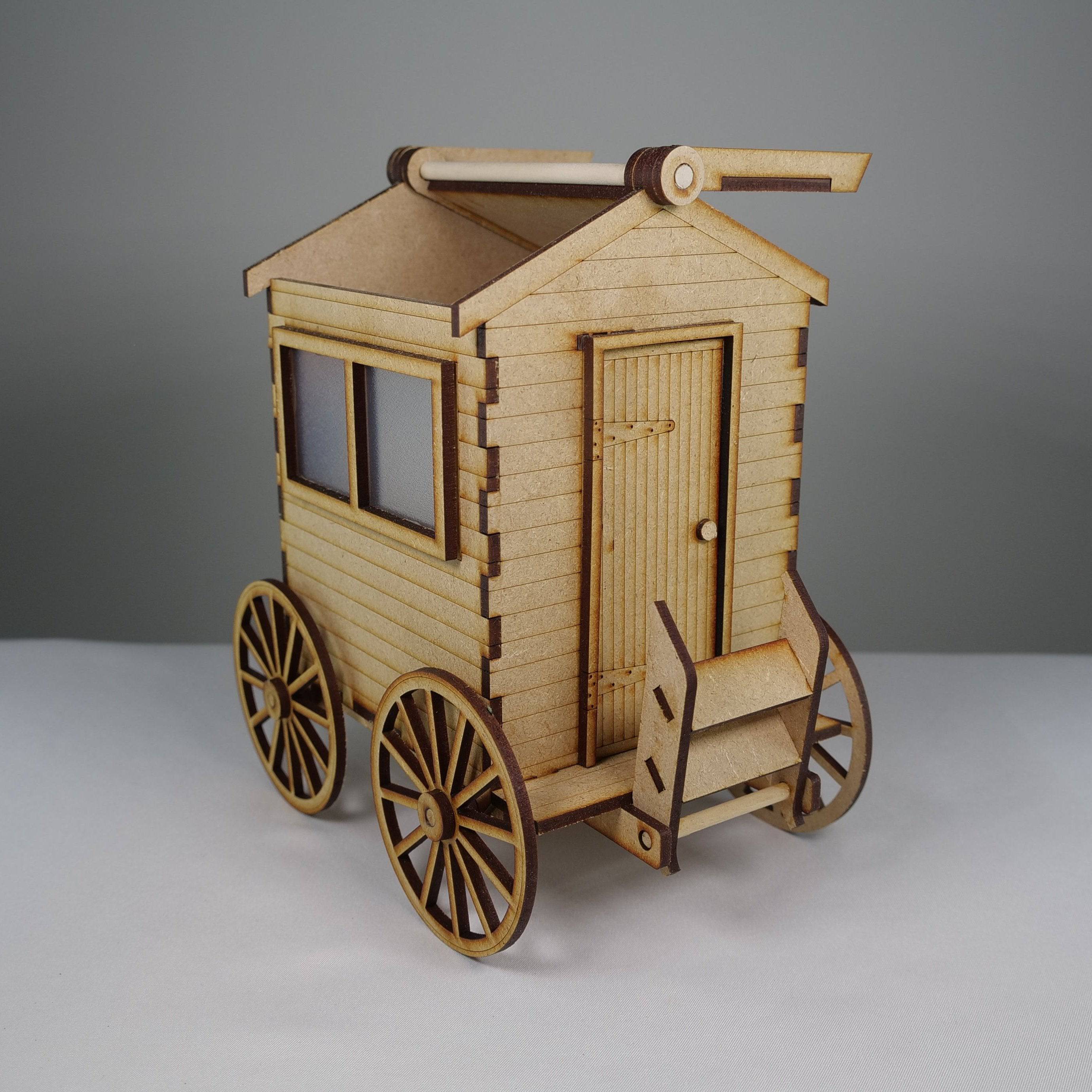 Curious Rabbit flatpack beach bathing hut model kit, assembled and displayed outdoors with a sandy beach background.