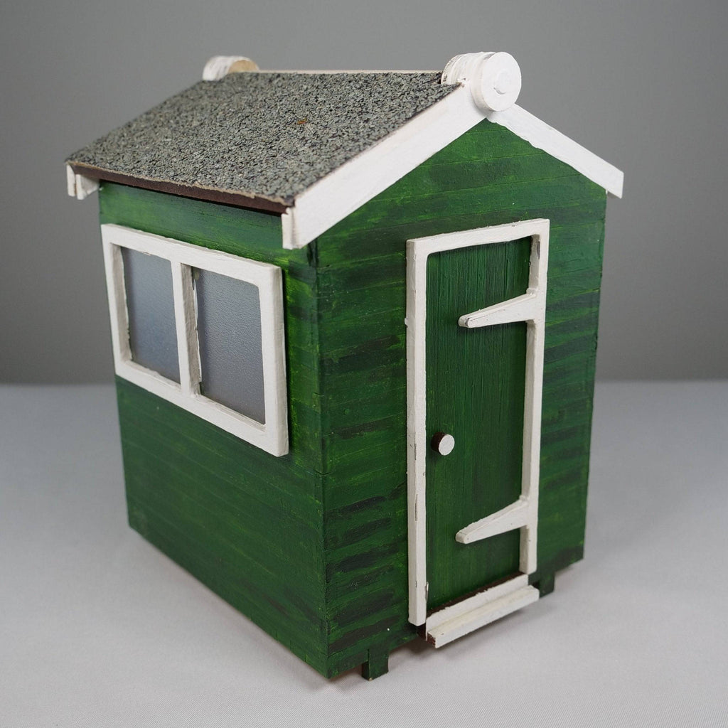 Curious Rabbit garden shed flatpack model kit showing assembled wooden garden storage shed with door and window.