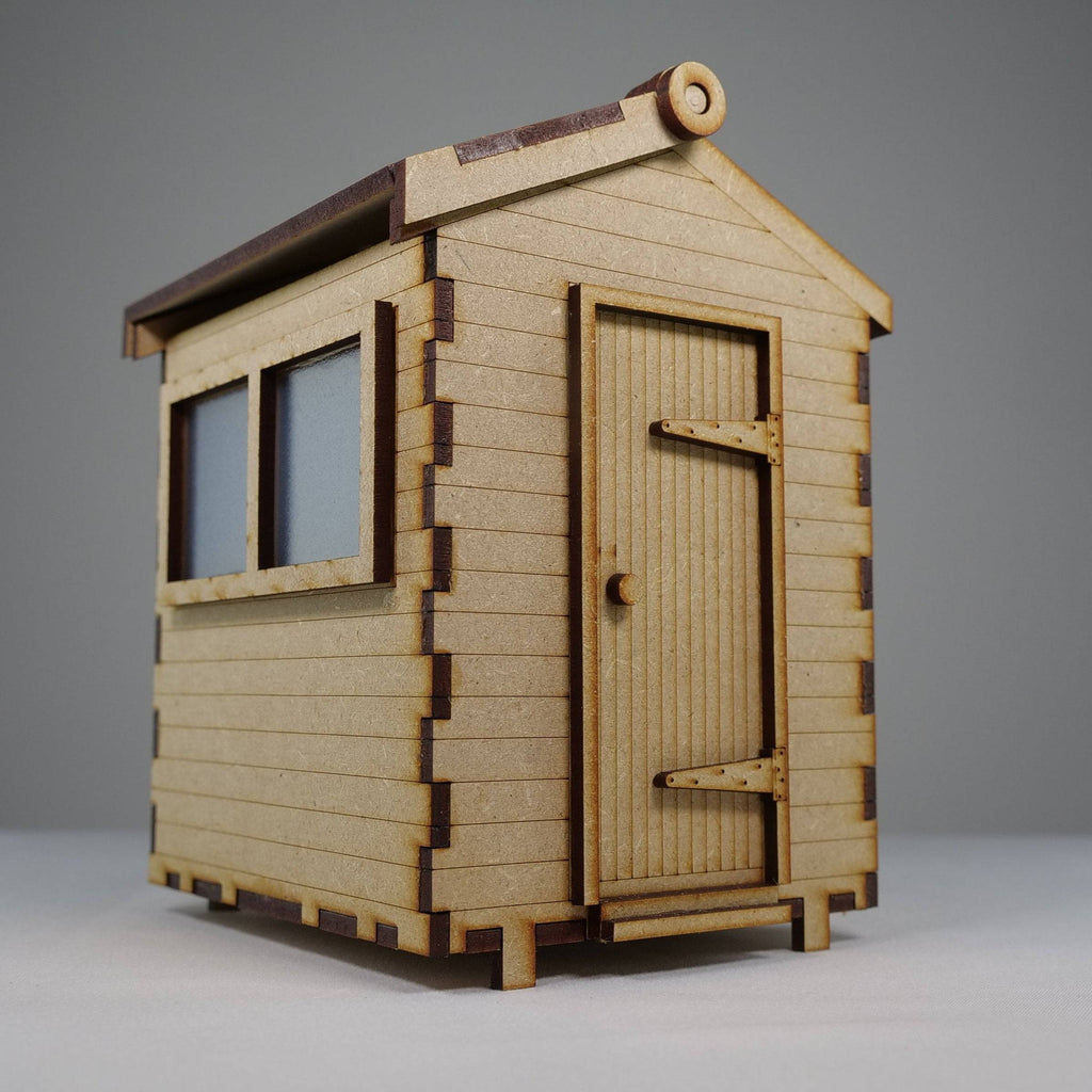 Curious Rabbit garden shed flatpack model kit, showing assembled wooden garden shed with open door and roof details.