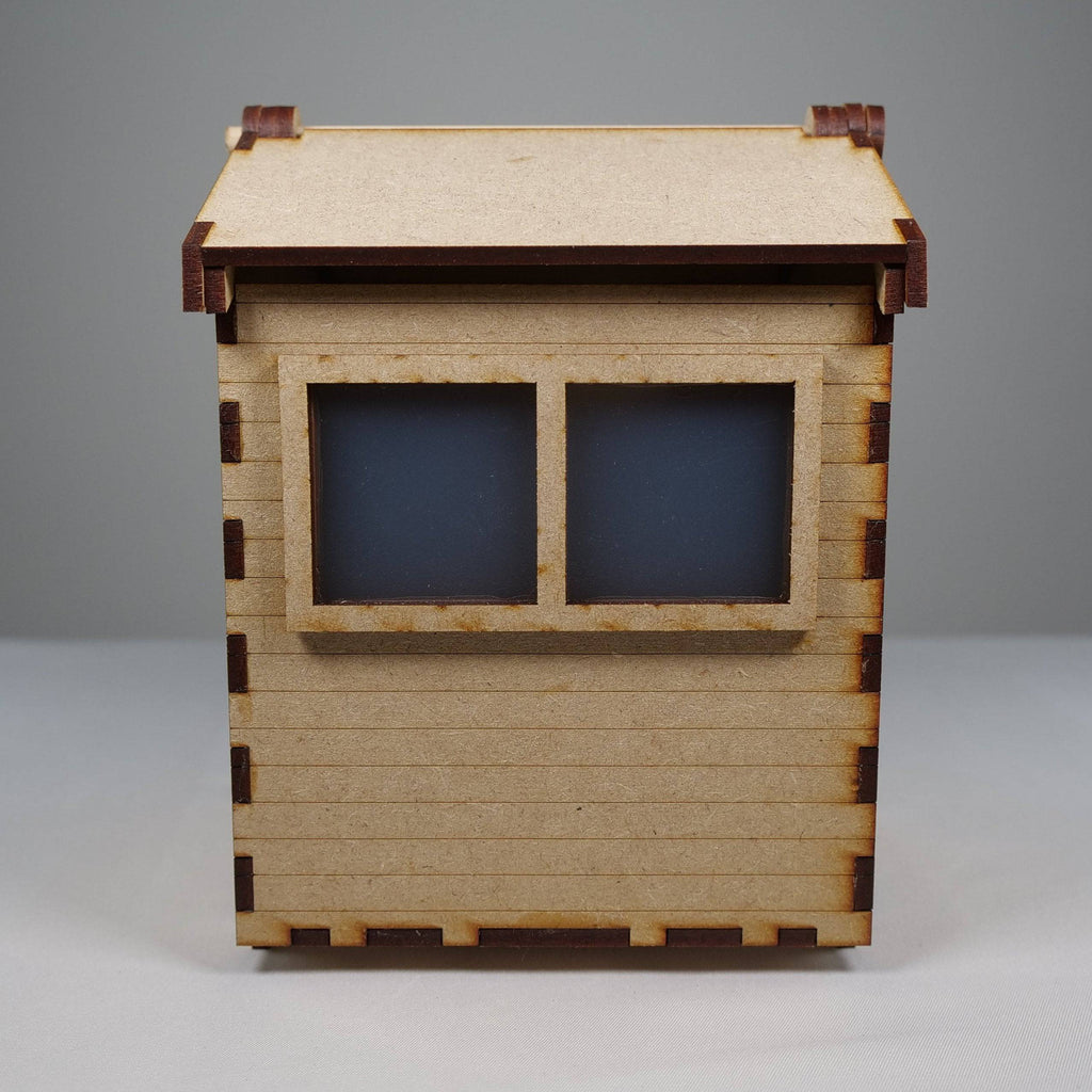 Curious Rabbit garden shed flatpack model kit with wooden panels and roof, ready for assembly in outdoor garden space.