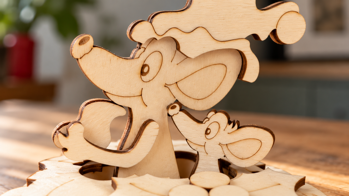 A close-up of a wooden mouse and child puzzle piece set, showing laser-cut light wood pieces assembled on a wooden surface with a softly blurred indoor background.